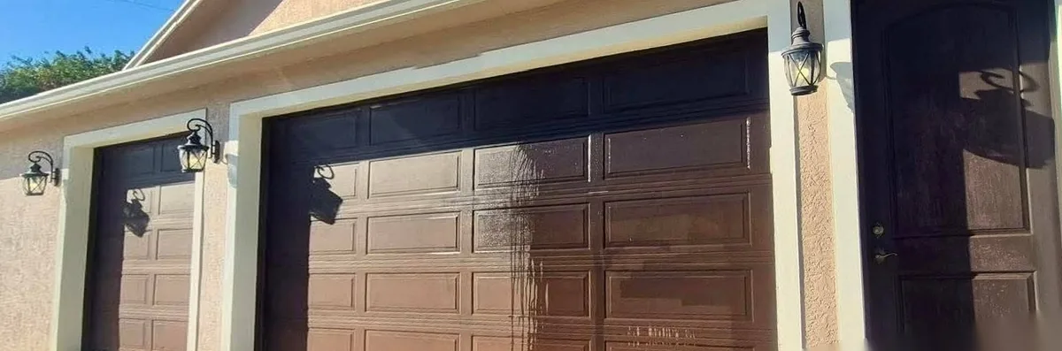 Before: faded, chalky brown garage doors and side door with a pressure washer in the drive