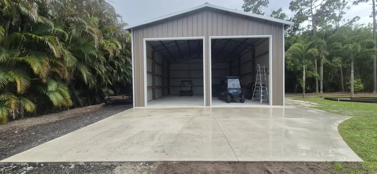 Front of a finished two-bay pole barn with both roll-up doors open