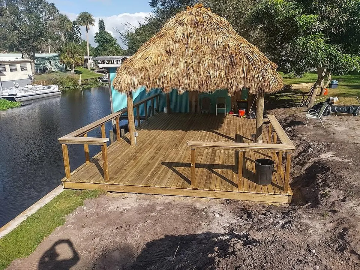 Wood deck and railing around a waterfront tiki hut