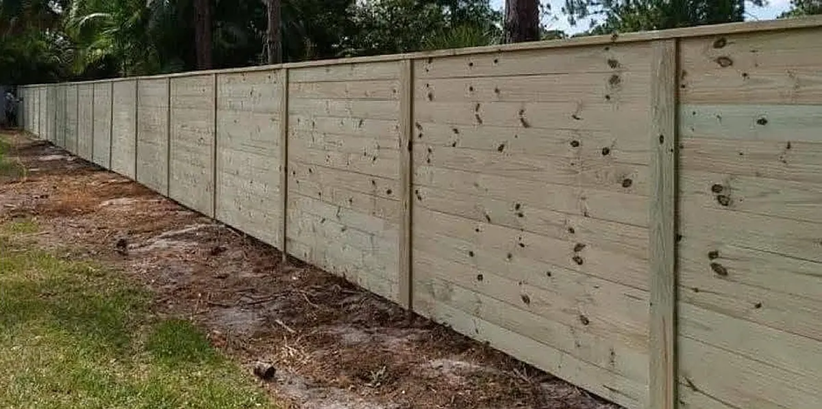 Horizontal board privacy fence running along a property line