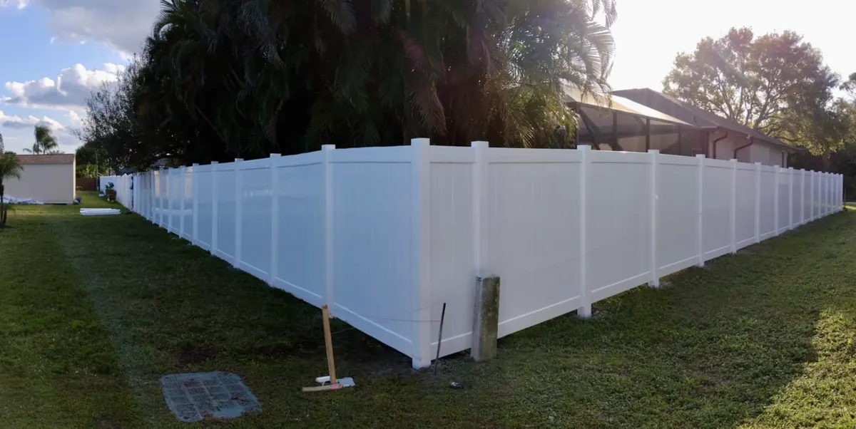 New white PVC privacy fence along a backyard