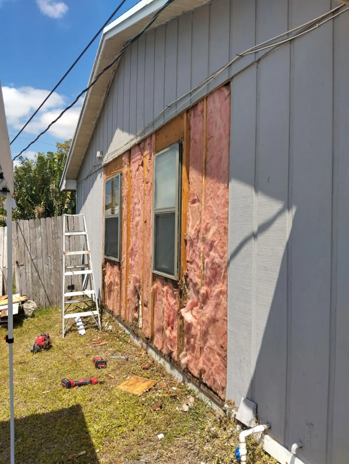 Old siding removed from a wall down to the framing and insulation